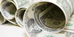 Close-up on rolled up dollar sheets used by artist Santiago Montoya in his works.